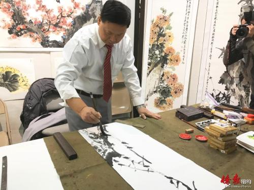 中國僑網(wǎng)馬金虎現(xiàn)場揮毫潑墨。(美國《僑報(bào)》/陳辰 攝)