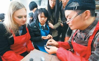 中國僑網(wǎng)圖為來自俄羅斯的留學(xué)生在周寶康(右)指導(dǎo)下學(xué)習(xí)制作泥叫叫。 楊 雨 攝(人民視覺)