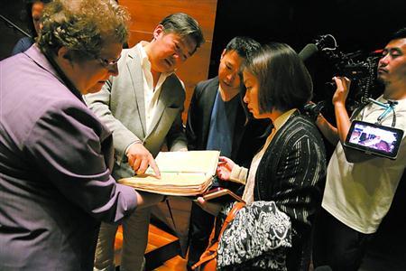 中國僑網(wǎng)克里斯緹娜(左一)介紹紀(jì)念冊內(nèi)容。 蔡磊磊 攝