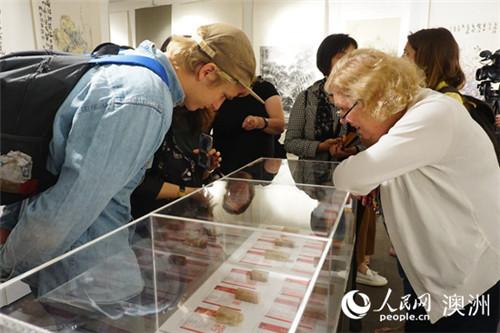中國僑網(wǎng)當?shù)孛癖娦蕾p展出的篆刻作品(攝影 羅小紅)