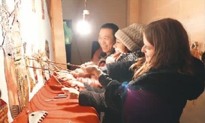 中國僑網(wǎng)伊莉和白皓月在學(xué)皮影戲