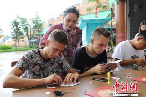 中國(guó)僑網(wǎng)饒寶蓮正在指導(dǎo)“洋徒弟”剪紙 李星凱 攝