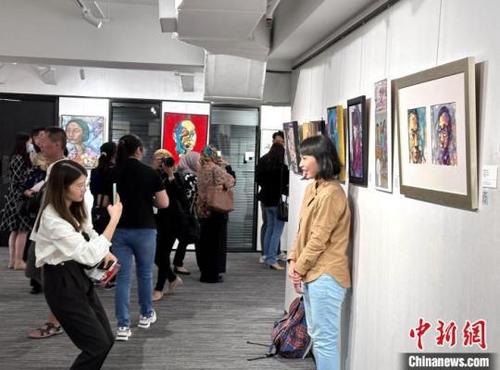 中國僑網(wǎng)畫展吸引當(dāng)?shù)馗髯迕癖娪^展 陳悅 攝
